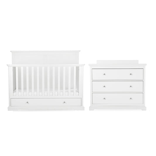 White baby nursery furniture set featuring a convertible crib with built-in storage drawers and a matching three-drawer dresser with small round silver knobs, shown on a plain white background.