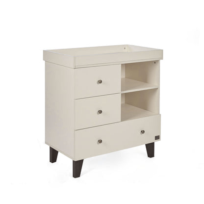 An off-white changing table with three drawers, open shelving, and dark brown tapered legs, shown on a plain white background.