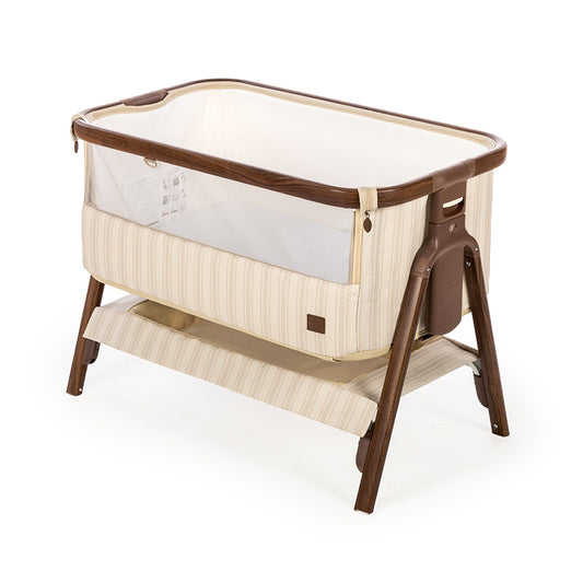 A baby bassinet with a cream and beige striped fabric body, a white mesh side panel, and a dark brown wooden frame and legs, shown on a white background.