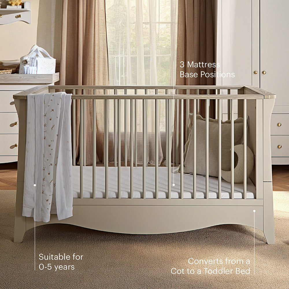 A cream-colored wooden toddler bed crib shown in a styled nursery setting, featuring text overlays that highlight its features: '3 Mattress Base Positions', 'Suitable for 0-5 years', and 'Converts from a Cot to a Toddler Bed'.
